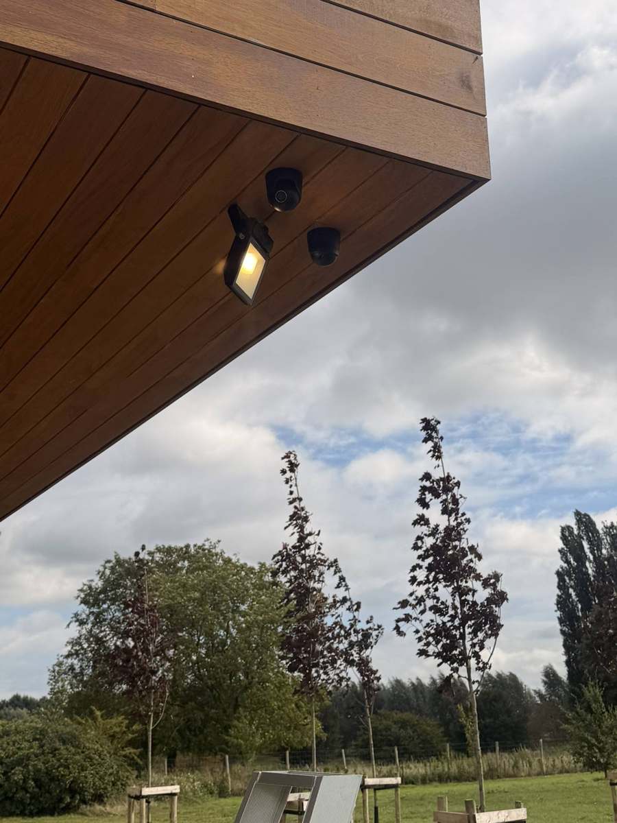 Buitenlamp en detectoren onder een dakoverstek.
