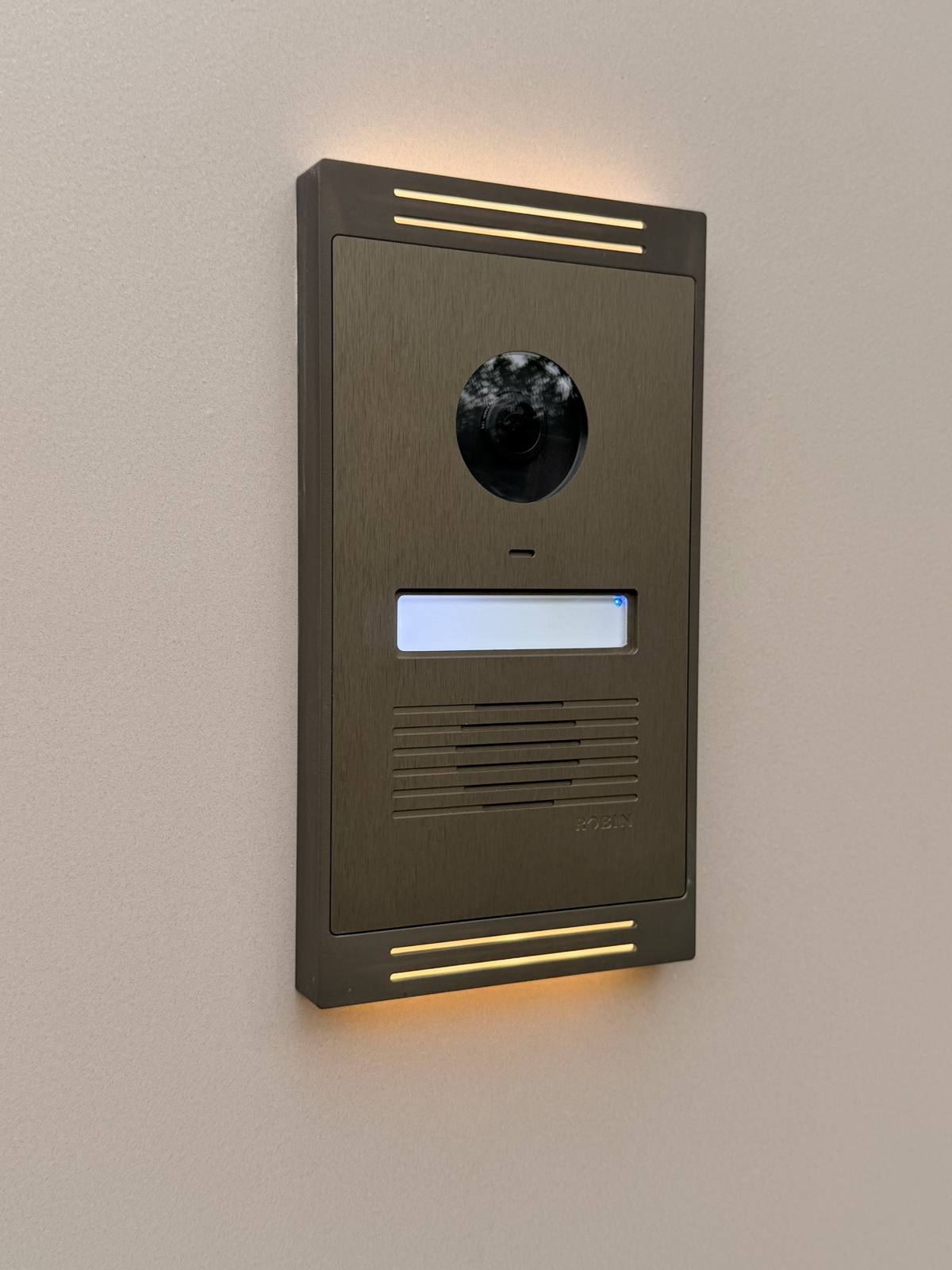 Videofoon met camera en verlichting aan een gevel.